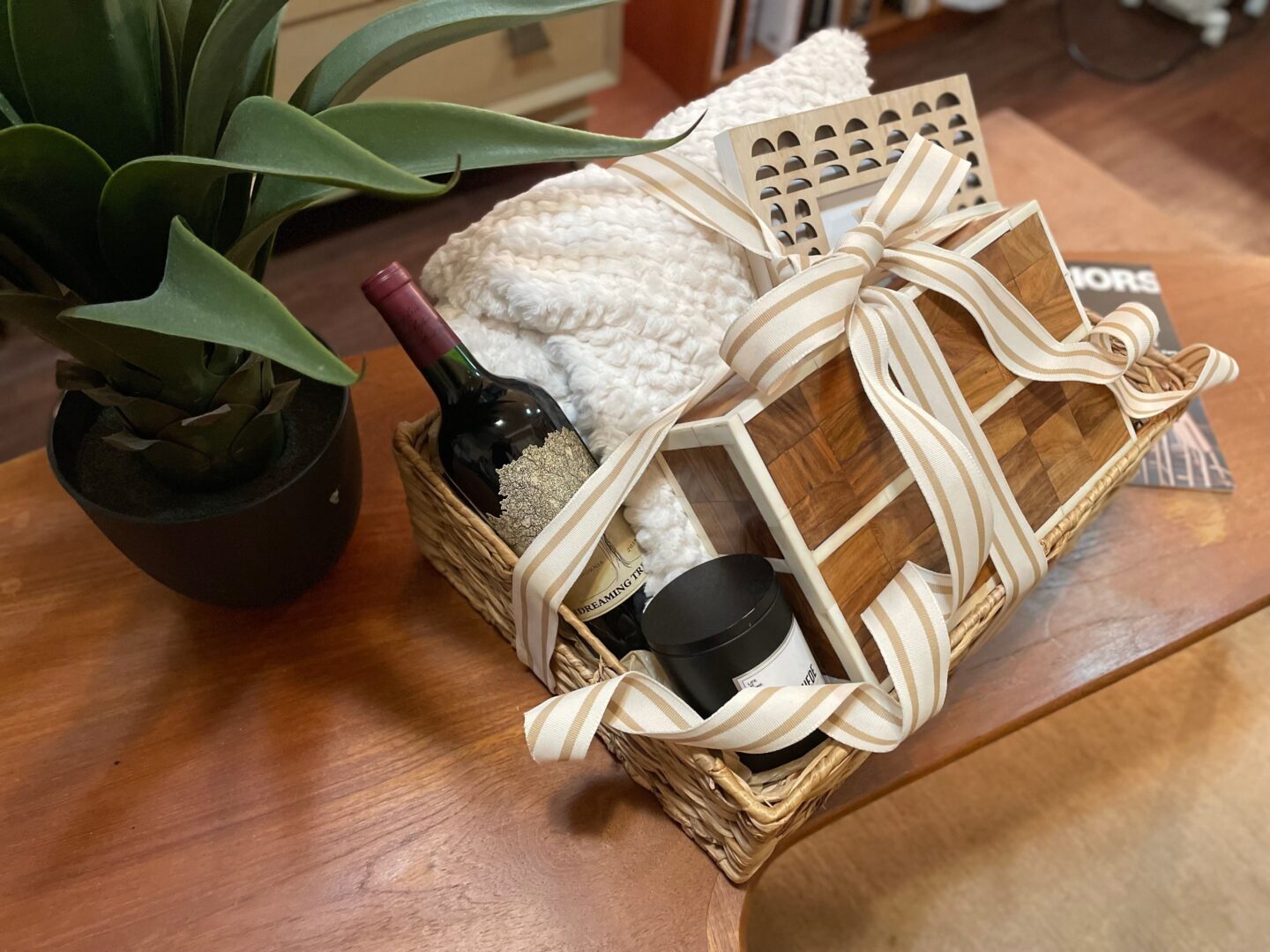 A basket with wine and towels on top of the table.
