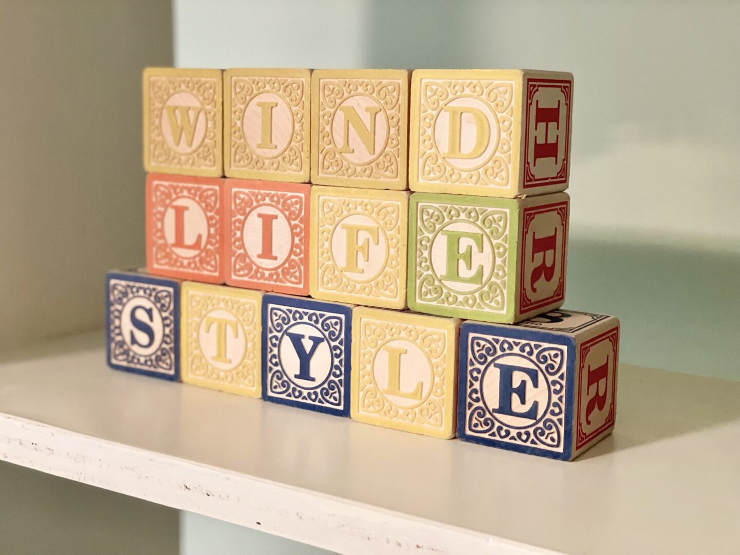 A stack of wooden blocks with letters on top.